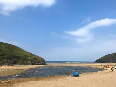 a beach with a blue tent on the sand at 2 Europa Court in Newquay