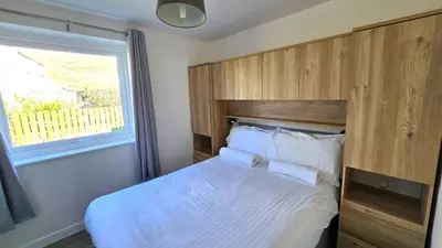 a bedroom with a large bed with a wooden headboard at 10 Wheal Ramoth in Perranporth