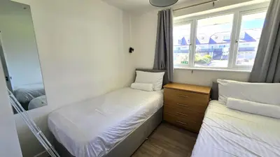 a small bedroom with two beds and a mirror at 10 Wheal Ramoth in Perranporth