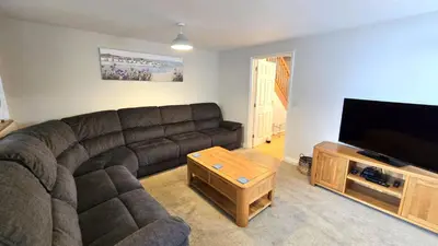 a living room with a couch and a flat screen tv at Gwel Angarder in Perranporth