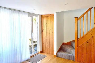 a staircase in a house with a sliding glass door at Gwel Angarder in Perranporth