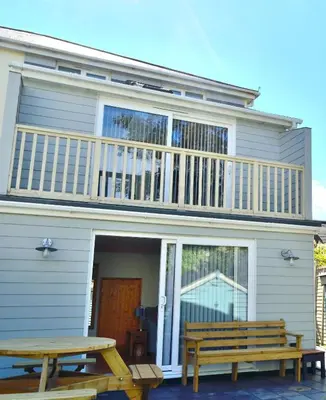 a house with two picnic tables in front of it at Gwel Angarder in Perranporth