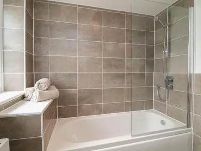 a bathroom with a shower and a bath tub at Beacon House in St. Agnes