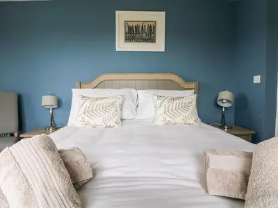 a bed with white sheets and pillows in a bedroom at Beacon House in St. Agnes
