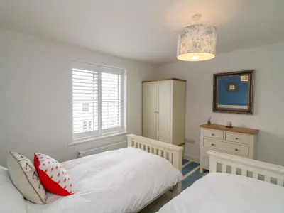 a bedroom with two beds and a window at Beacon House in St. Agnes
