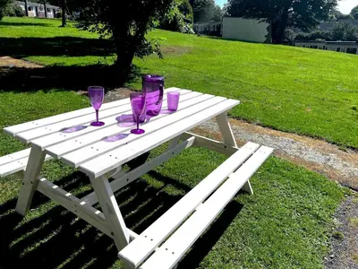 a picnic table with purple wine glasses on it at Holiday home, Camelford, Cornwall in Camelford