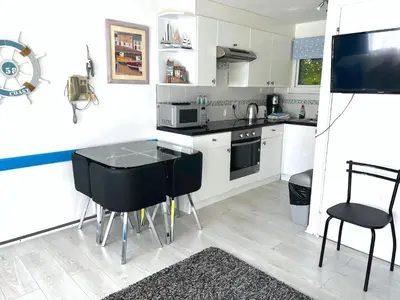 a kitchen with a black table and chairs in it at Holiday home, Camelford, Cornwall in Camelford