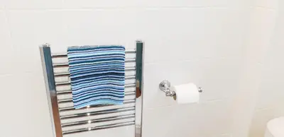 a towel rack in a bathroom with a blue towel at Amazing Granite Henge and Swimming Pool in Looe