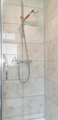 a shower with a glass door in a bathroom at Amazing Granite Henge and Swimming Pool in Looe