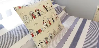 a bed with a sheet with houses on it at Amazing Granite Henge and Swimming Pool in Looe