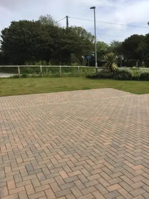 a brick paved area with a fence and grass at 2 Lapwing Drive in Hayle