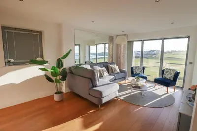 a living room with a couch and a table at Newquay Fistral Beach View in Newquay