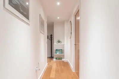 a hallway with white walls and a hardwood floor at Newquay Fistral Beach View in Newquay