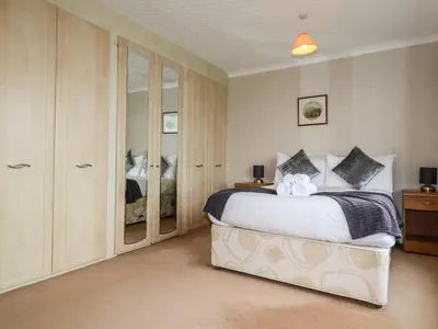 a bedroom with a large white bed and cabinets at Gwel An Mor in Newquay