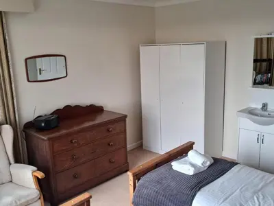 a bedroom with a bed and a dresser and a sink at Gwel An Mor in Newquay
