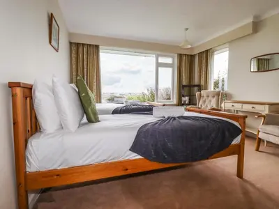 a bedroom with a large bed with a window at Gwel An Mor in Newquay