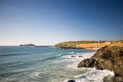 a view of a beach with rocks and the ocean at Towennan - four bedroomed apartment in quiet seaside village. in Gwithian
