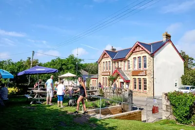 a group of people standing outside of a house at Towennan - four bedroomed apartment in quiet seaside village. in Gwithian