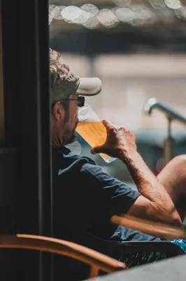 a man sitting in a chair drinking a drink at Polzeath Beach House in Polzeath