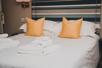 a pile of towels sitting on a bed at Polzeath Beach House in Polzeath