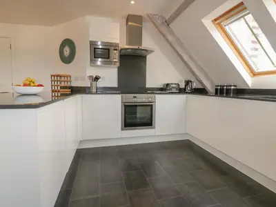a kitchen with white cabinets and a counter top at Stores & Supplies in Bodmin