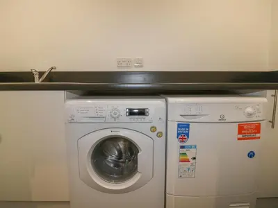 a washing machine and a dryer in a kitchen at Stores & Supplies in Bodmin