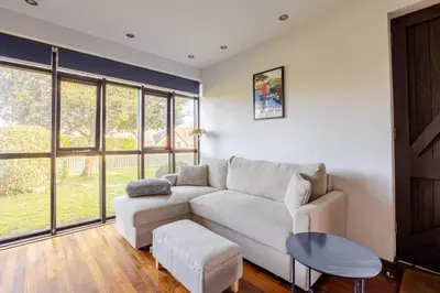 a living room with a couch and a table at Charming Summerhouse Annexe in lush gardens in Fowey in Fowey