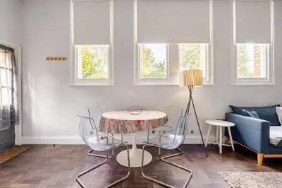 a living room with a table and chairs and a couch at Classroom Flat Suite in a converted school in Fowey town centre in Fowey