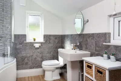 a bathroom with a sink toilet and a mirror at Trevarrow Cottage in Coverack