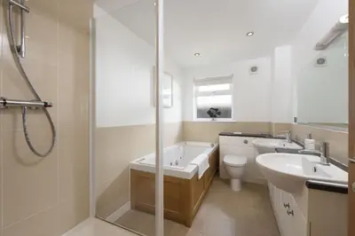 a bathroom with a tub and a sink and a toilet at Lodge 40 - Resort & Spa & Hot Tub & Free Wi-Fi in Saint Columb Major