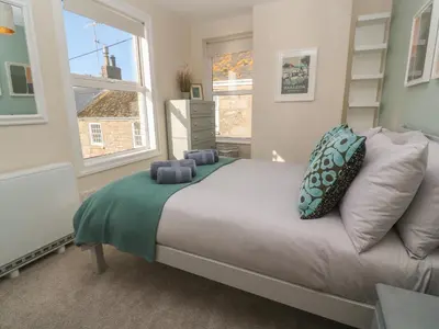 a bedroom with a bed and a window at Nana's House in Marazion