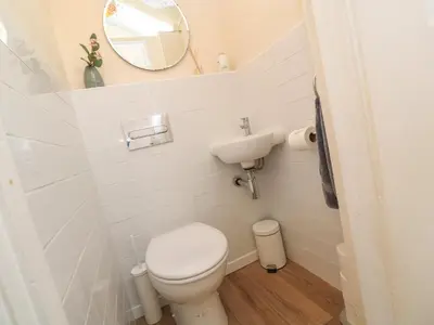 a small bathroom with a toilet and a mirror at Nana's House in Marazion