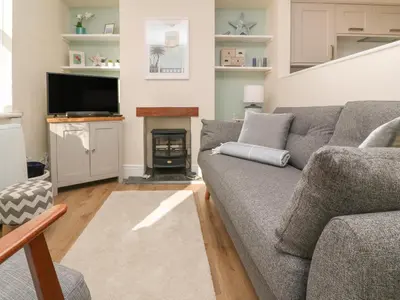 a living room with a couch and a fire place at Nana's House in Marazion