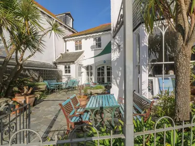 a patio with chairs and a table in front of a house at Nana's House in Marazion