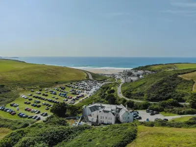 an aerial view of a parking lot next to the beach at 10 The Whitehouse, Watergate Bay in Mawgan Porth