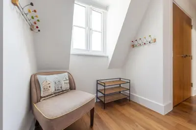 a chair sitting in a hallway with a window at 10 The Whitehouse, Watergate Bay in Mawgan Porth