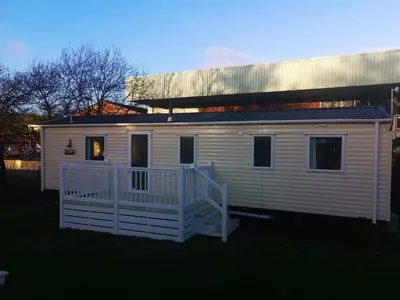 a white tiny house in front of a building at 67 Newquay Getaway in Porth