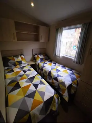 two beds in a small room with a window at 67 Newquay Getaway in Porth