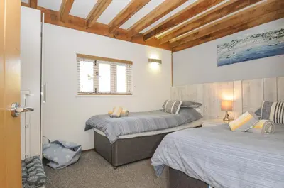 a bedroom with two beds and a window at Stow Cottage in Camelford