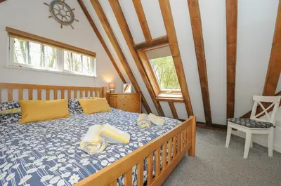 a bedroom with a bed with a blue and white comforter at Stow Cottage in Camelford