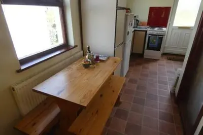 a kitchen with a wooden table and a window at Ferney Croft in Saint Erth