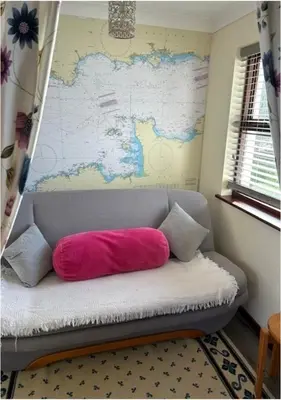 a pink pillow sitting on a couch in a room at Ferney Croft in Saint Erth