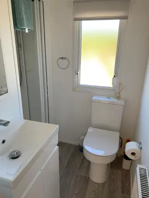 a white bathroom with a toilet and a window at Newquay Bay in Newquay