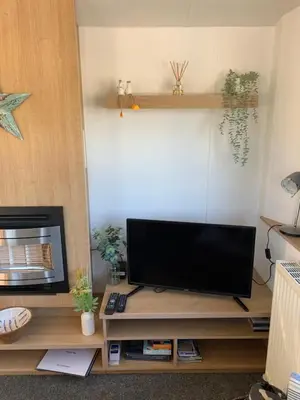 a flat screen tv sitting on top of a wooden entertainment center at Newquay Bay in Newquay