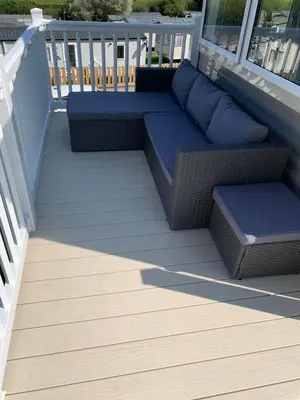 a patio with a couch and pillows on a deck at Newquay Bay in Newquay