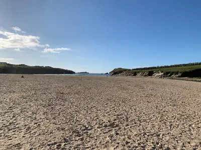 a sandy beach with footprints in the sand at Newquay Bay in Newquay