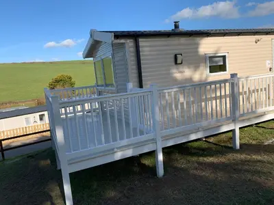 a mobile home with a white railing on a deck at Newquay Bay in Newquay