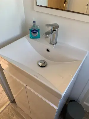 a white bathroom sink with a bottle of soap on it at Newquay Bay in Newquay