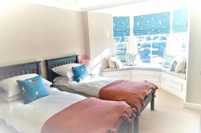 two beds in a room with a window at Avala in Perranporth