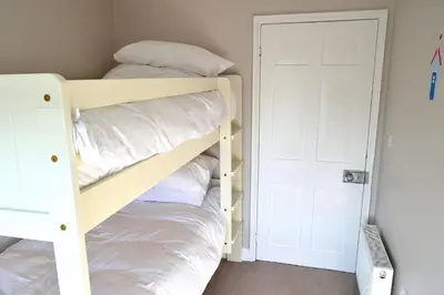 a bedroom with two bunk beds with white pillows at Avala in Perranporth